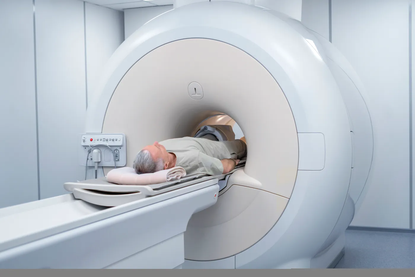 Homme âgé allongé sur la table coulissante d'un scanner IRM entrant dans le tunnel